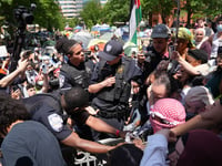 University Police officers tussle with protesters who tried to raise the Palestinian flag on the campus flagpole