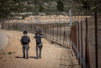 Israeli border police officers patrol along the security fence, near the West Bank village of Bayt Iksa