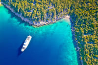 Aerial view of luxury large yacht anchored in turquoise bay 