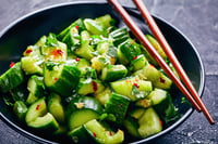 Chinese Smashed Cucumber salad, pai huang gua, in a black bowl with chopsticks