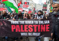 Pro-Palestinian muslim protesters hold a banner saying "From the river to the sea..." 