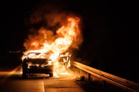 Firefighters extinguish burning car on highway 