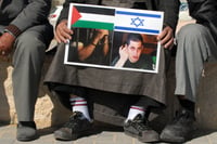 Arab Israeli men holding a poster of Gilad Shalit who captured by Palestinian militants, and held for five years