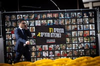 Man passing a poster for the release of the hostages.