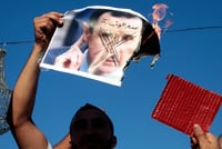 Protestors burning Assad's image.