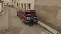 Man putting a body in the trunk of a car