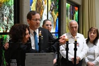 President Herzog lighting the menorah in the presence of families of hostages.