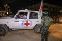 Hamas terrorist standing next to Red Cross vehicle