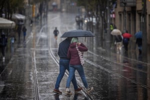 People seen during heavy rain on Jaffa street in Jerusalem, on January 12, 2024.