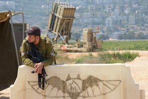 An Israeli sodier is seen next to an Iron Dome Anti Missile rockets launcher in Haifa, Israel.