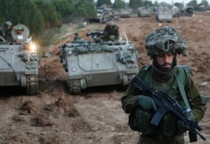 Israeli infantry reservist soldiers prepare to cross to the Gaza Strip in a deployment area near the Israeli-Gaza border 