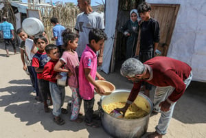 Palestinians receive food from kitchens designated for making food (Al-tikia) and in shelter tents for the displaced, in Deir al-Balah in the central Gaza Strip, on June 10, 2024. 