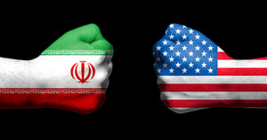 Flags of USA and Iran painted on two clenched fists facing each other 