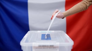 A French voter throwing a voting ballot into the sealed box during elections in France