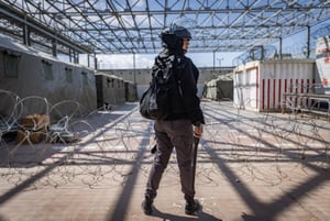 A member of the Israel Prison Service stands guard next to tents with Hamas terrorists caught during the October 7th massacre