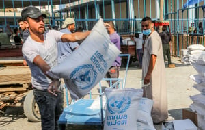 Palestinians come to receive food aid from an UNRWA distribution centre in Khan Younis 