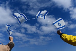 Thousands of Israelis hold signs and wave the Israeli flag on Halacha bridge in Tel Aviv