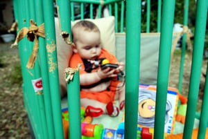 An Israeli baby is playing in his damaged bed at Kibbutz Mefalsim caused by rocket fired from the Gaza Strip 