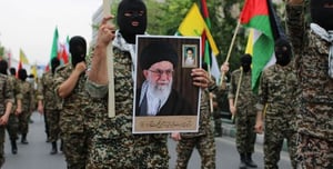 Masked fighters hold a picture of Khamenei