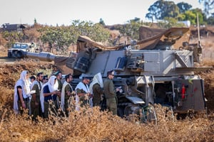 Israeli soldiers pray next to their artillery units near the Israeli border with Lebanon, northern Israel, September 29, 2024. 