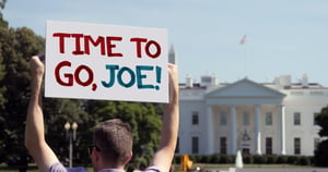 American holds up a sign which says "Time to go, Joe!"