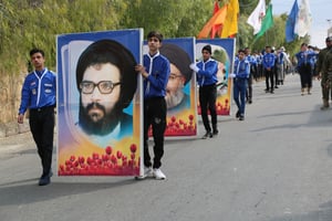 Hezbollah scouts carrying photos of dead Hezbollah leaders.