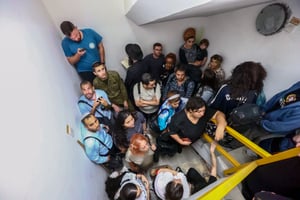 Israelis take cover inside a bomb shelter as an air raid siren is sounded