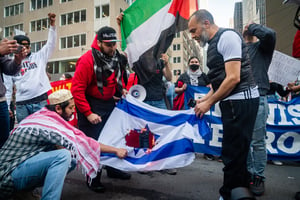 Protestors burning an Israeli flag.