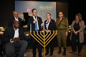 President Herzog lighting the menorah.