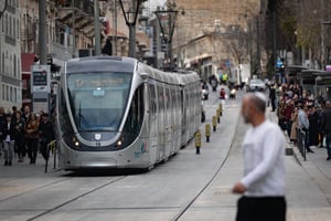 People walking next to the Light rail on Jaffa Street in central Jerusalem, January 5, 2025