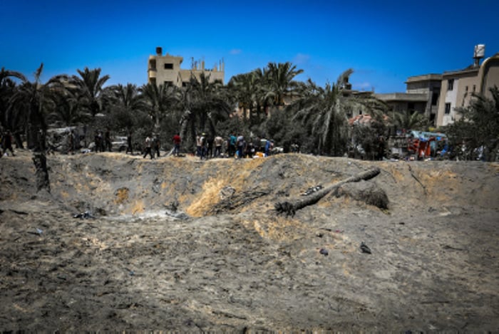 Palestinians inspect the damage caused from an Israeli airstrike in the Al-Mawasi area of Khan Yunis, in the southern Gaza Strip, on July 13, 2024. 