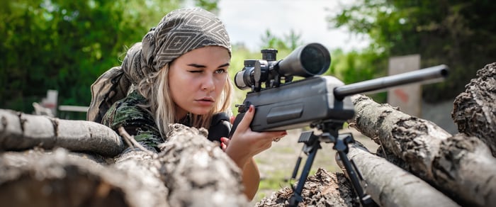 Female soldier shooting with sniper rifle