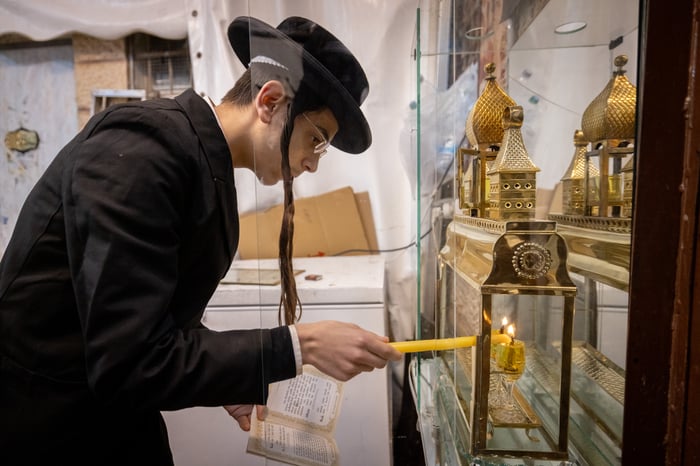 Ultra-Orthodox Jews light candles on Hanukkah, in Jerusalem's Mea Shearim neighbourhood on December 26, 2024