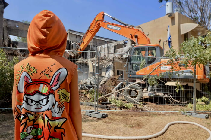 A bulldozer destroys a house that was damaged during the 7th of October massacre in Kibbutz Be'eri, July 7, 2024. 