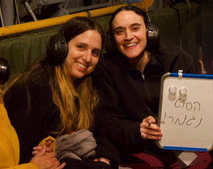 2 of the 3 released hostages holding a sign "the nightmare is over"