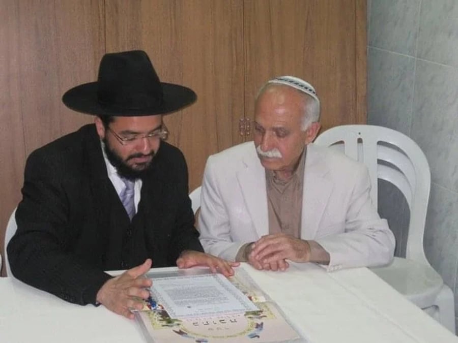 My grandfather is sitting to sign the marriage contract with the rabbi who is officiating the ceremony 