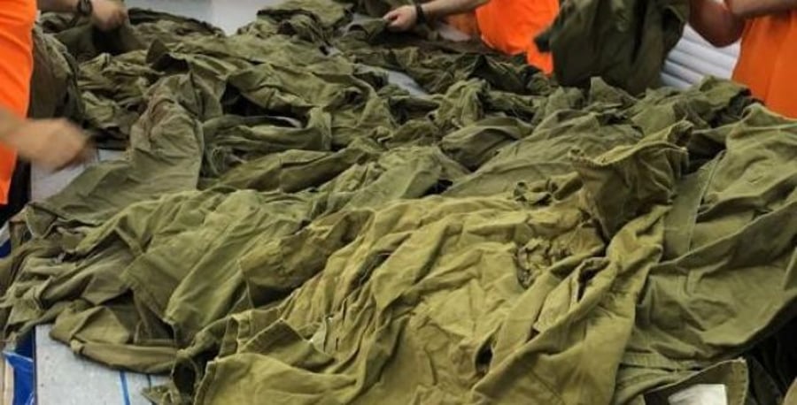 Prisoners handling army uniforms.