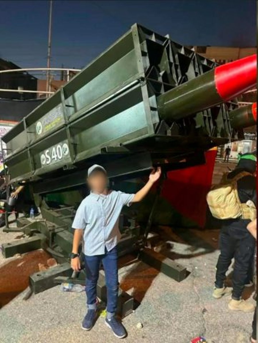 A Gazan boy next to rocket launchers