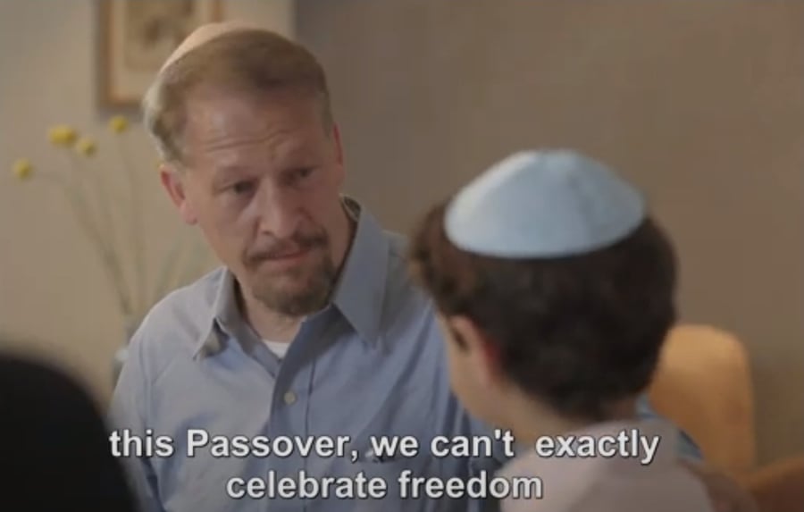Father explaining to son how this Passover is different in Hostages Families Forum ad.
