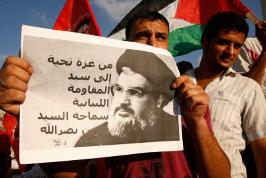 A Palestinian protester from the Popular Front for the Liberation of Palestine (PFLP) holds a picture of Hassan Nasrallah, the head of Lebanon's militant Shiite Muslim movement Hezbollah