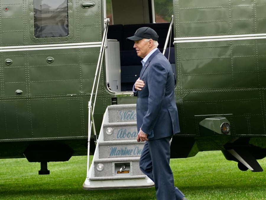  President Biden, accompanied by Deputy Chief of Staff Annie Tomasini and other members of his staff, walks toward his helicopter.