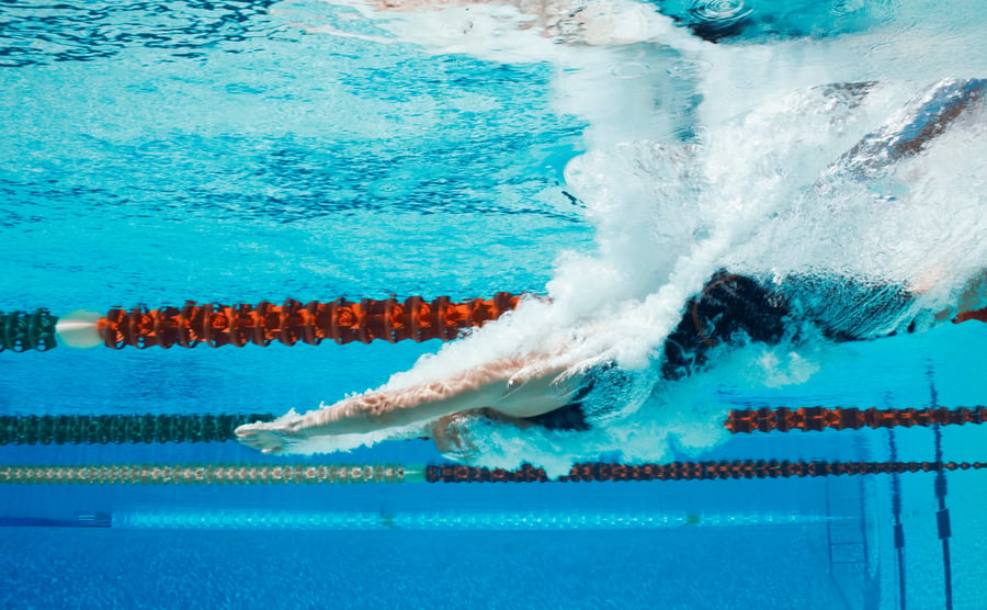 Competitive swimmer diving into pool 