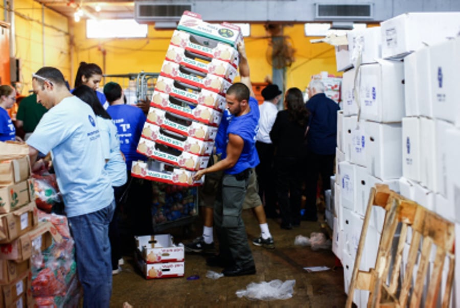 Israeli soldiers prepare food packages at a distribution center for needy people