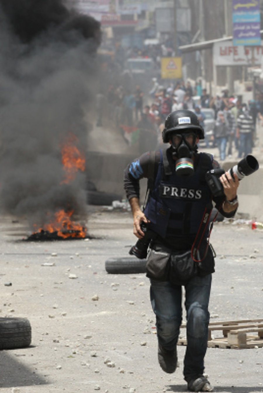 Well known Israeli press photographer Ziv Koren walking though Kalandia on Nakba Day