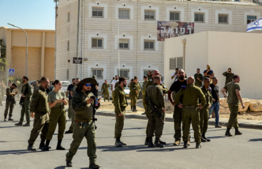 Israeli soldiers guard while demonstrates protest against the detention of Israeli reserve soldiers 