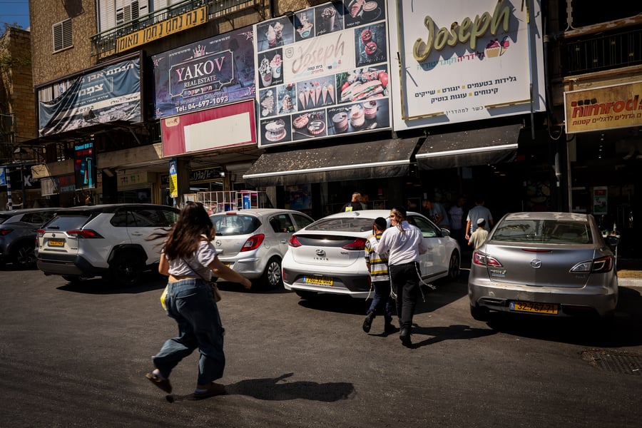 People take cover as a siren warns of incoming missiles fired from Lebanon, in the northern Israel city of Tzfat, September 26, 2024