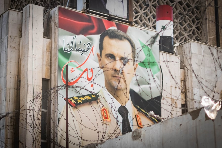 Bashar Assad's image, behind barbed wire in Damascus, Syria.