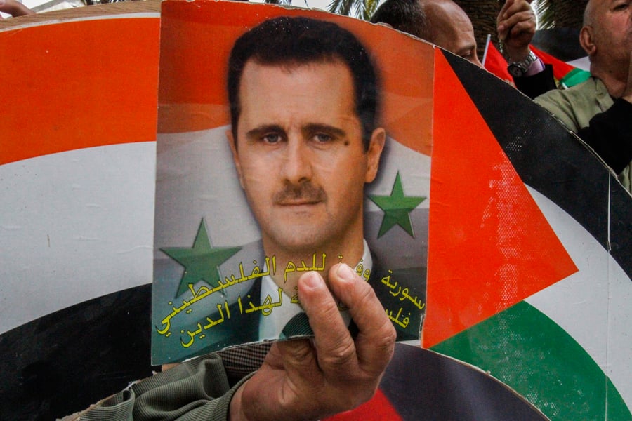 Palestinians holding Syrian flags and pictures of President Bashar al-Assad during a march in the city of Nablus in the West Bank 