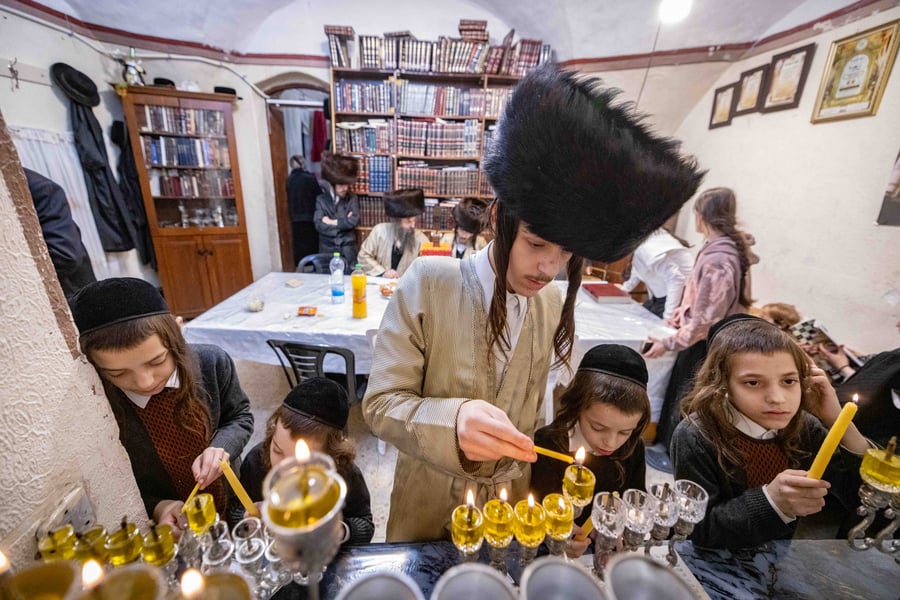 Ultra-Orthodox Jews light candles during the Jewish holiday of Hanukkah, in Jerusalem's Mea Shearim neighbourhood on December 28, 2024