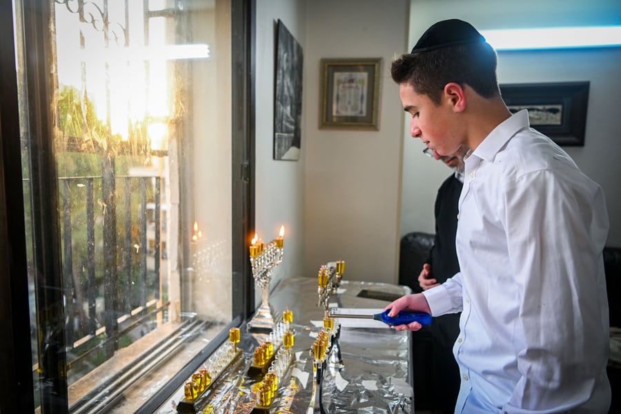 A Jewish family light candles on during the Jewish holiday of Hanukkah, in Jerusalem on December 27, 2024.